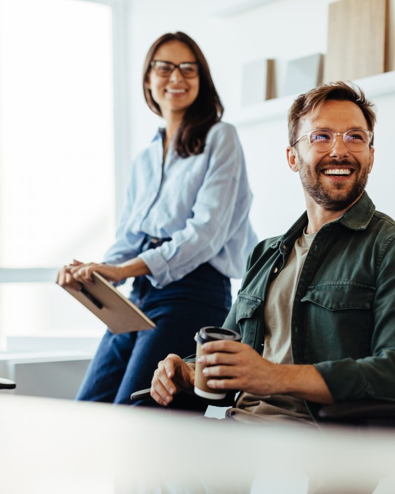 Professionals listening to a discussion in an office. Group of happy business people having a team meeting.